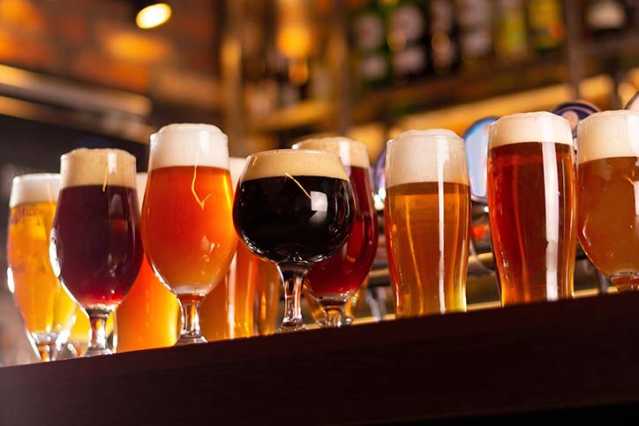 Verschillende speciaalbieren met een volle schuimkraag naast elkaar op de bar.